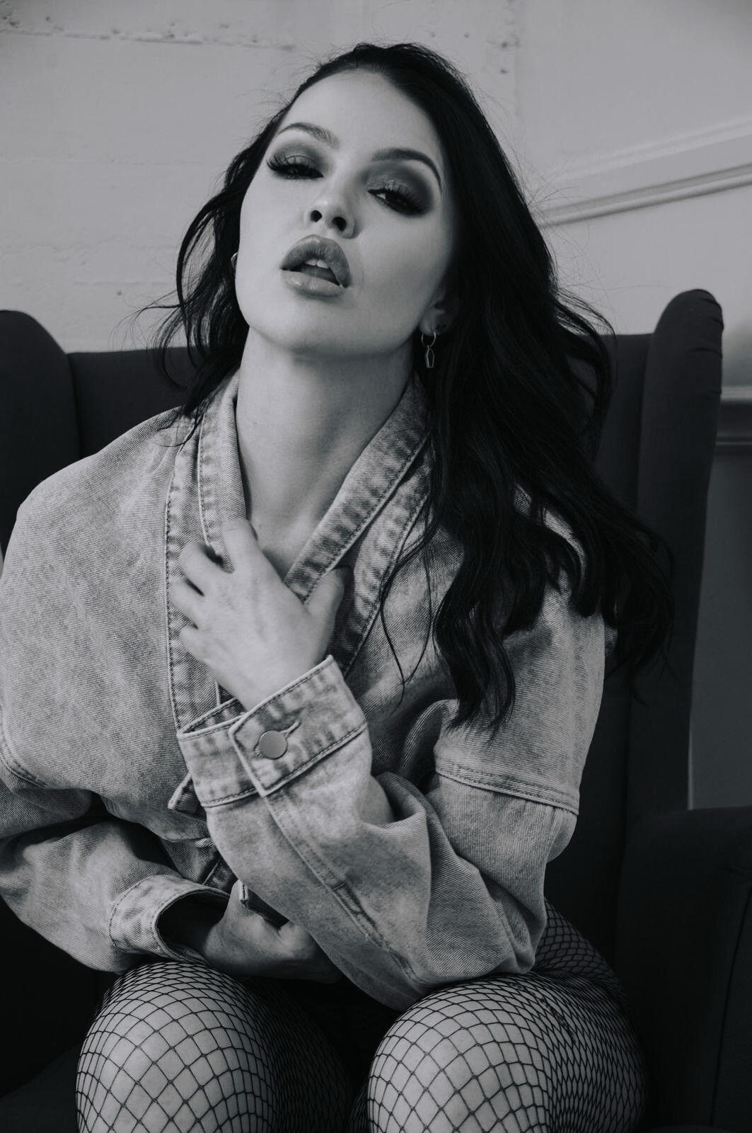 Heather Grace Hancock Moody black and white shot of a woman in a denim jacket, gazing confidently at the camera.